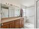 The bathroom features a large mirror, a walk-in shower, with safety bars, tile and a wooden cabinet at 5235 Keenes Pheasant Dr, Windermere, FL 34786