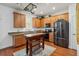The kitchen features wooden cabinets, a black refrigerator and oven, with a wooden island and a decorative rug at 5235 Keenes Pheasant Dr, Windermere, FL 34786