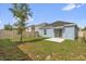 A serene backyard featuring green grass, a tree, a concrete patio, and a privacy fence offers a relaxing outdoor space at 555 Jett Ln, Davenport, FL 33837