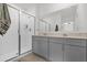 Bathroom featuring double vanity sinks, gray cabinets, and a glass-enclosed shower at 555 Jett Ln, Davenport, FL 33837