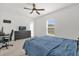 Bedroom with carpet and ceiling fan, with a TV on a dresser, and a door to the bathroom at 555 Jett Ln, Davenport, FL 33837