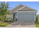 Charming single Gathering home featuring light blue exterior paint and an attached two car garage at 555 Jett Ln, Davenport, FL 33837
