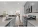 Bright kitchen open to the living area featuring gray cabinets, stainless appliances and tile floors at 555 Jett Ln, Davenport, FL 33837