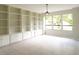 Bright living room featuring custom built-in shelving and large windows at 5607 Spring Run Ave, Orlando, FL 32819