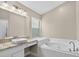 Bright bathroom with a vanity, marble countertops, tub, and a window at 632 Bridge Creek Blvd, Ocoee, FL 34761