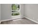 Bedroom view showcases a lush front yard through window, gray walls, and wood-look flooring at 632 Bridge Creek Blvd, Ocoee, FL 34761