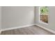 Bedroom showcasing garden view through window, completed with gray walls and wood-look flooring at 632 Bridge Creek Blvd, Ocoee, FL 34761