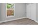 Bedroom featuring closet and a window overlooking garden, with gray walls and wood-look flooring at 632 Bridge Creek Blvd, Ocoee, FL 34761