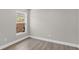 Bedroom showcasing fenced yard view through window, completed with gray walls and wood-look flooring at 632 Bridge Creek Blvd, Ocoee, FL 34761