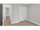 Bedroom featuring closet and doorway to other room, with gray walls and wood-look flooring at 632 Bridge Creek Blvd, Ocoee, FL 34761