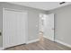Bedroom featuring closet and doorway to bathroom with grey walls and wood-look flooring at 632 Bridge Creek Blvd, Ocoee, FL 34761