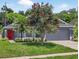 Charming single-story home boasts a red door, well-manicured lawn, and mature landscaping at 632 Bridge Creek Blvd, Ocoee, FL 34761