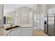 Bright kitchen with stone countertops, stainless appliances, and open view to laundry area and backyard at 632 Bridge Creek Blvd, Ocoee, FL 34761