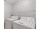 Bright laundry area features white washer, dryer, and a shelf for organizing essentials at 632 Bridge Creek Blvd, Ocoee, FL 34761