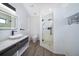 Modern bathroom featuring a vessel sink, wood-look flooring, an illuminated mirror, and a glass-enclosed shower at 6512 Grosvenor Ln, Orlando, FL 32835