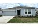 Charming single-story home with a gray stucco exterior, well-manicured lawn, and an attached garage at 680 Sand Pine Ln, Haines City, FL 33844