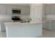 A modern kitchen featuring stainless steel appliances, an island, and ample cabinet space at 680 Sand Pine Ln, Haines City, FL 33844