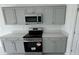 Close-up view of the kitchen with stainless steel appliances and light gray cabinets at 680 Sand Pine Ln, Haines City, FL 33844