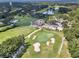 High-angle aerial view of a golf course, lake, and clubhouse amid a lush, green landscape at 6836 Bittersweet Ln, Orlando, FL 32819