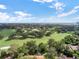 Expansive aerial view of a golf course community with mature trees and distant city skyline at 6836 Bittersweet Ln, Orlando, FL 32819