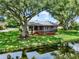 The backyard has mature trees, a screened lanai, and water views at 6836 Bittersweet Ln, Orlando, FL 32819