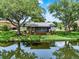The backyard has mature trees, a screened lanai, and water views at 6836 Bittersweet Ln, Orlando, FL 32819