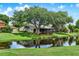 Backyard view of home overlooking water with mature trees providing shade at 6836 Bittersweet Ln, Orlando, FL 32819