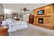 Spacious bedroom with a ceiling fan, fireplace, wood wall decor, carpet, and an en-suite bathroom at 6836 Bittersweet Ln, Orlando, FL 32819