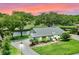 Stunning home featuring a well-manicured lawn, lush landscaping, and tranquil water views, perfect for luxurious living at 6836 Bittersweet Ln, Orlando, FL 32819