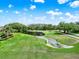 Picturesque view of the golf course with lush greenery, water feature and blue skies at 6836 Bittersweet Ln, Orlando, FL 32819