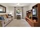 Bright living room features neutral tones, a comfortable sofa, and a large entertainment center for modern living at 6836 Bittersweet Ln, Orlando, FL 32819