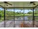 Spacious screened porch features a wooden floor, ceiling fans, and views of the golf course and pond at 6836 Bittersweet Ln, Orlando, FL 32819