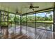 Spacious screened porch features a wooden floor, ceiling fans, and beautiful outdoor views at 6836 Bittersweet Ln, Orlando, FL 32819