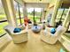 Bright sun room with four chairs, large windows and views of a pond and the grounds at 6836 Bittersweet Ln, Orlando, FL 32819