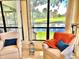 Comfortable sunroom with garden views, tiled floor, comfortable chairs and tables and large windows at 6836 Bittersweet Ln, Orlando, FL 32819