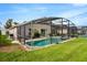 Enjoy the outdoor enclosed pool, chairs, table, and a lovely garden, surrounded by a well-maintained green lawn at 8152 Fan Palm Way, Kissimmee, FL 34747