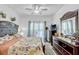 Bright bedroom features floral bedding, ceiling fan, and a view to the yard at 8152 Fan Palm Way, Kissimmee, FL 34747