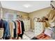 Cozy bedroom with beige walls, dresser, mirror, window, and rods to hang clothes in a walk-in closet at 8152 Fan Palm Way, Kissimmee, FL 34747