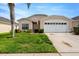 Charming single-story home featuring a two-car garage and a manicured front lawn at 8152 Fan Palm Way, Kissimmee, FL 34747