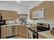 Efficient kitchen design with stainless steel appliances, light cabinets, and laminate countertops at 8152 Fan Palm Way, Kissimmee, FL 34747
