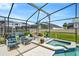 Enjoy the outdoor enclosed patio with a jacuzzi, chairs, table, and a lovely garden along the side for relaxation at 8152 Fan Palm Way, Kissimmee, FL 34747