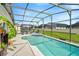 Enjoy the outdoor enclosed pool with a jacuzzi, chairs, table, and a lovely garden along the side for relaxation at 8152 Fan Palm Way, Kissimmee, FL 34747