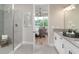 Bright bathroom with tiled glass shower, white cabinetry, and open view to Primary bedroom at 854 Junonia Blvd, New Smyrna Beach, FL 32168