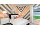 Stylish bedroom featuring striped accent wall, contemporary decor, and bright natural light at 854 Junonia Blvd, New Smyrna Beach, FL 32168