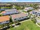 An aerial view of townhomes boasts a tiled roof, with a lakeside view in the background at 10108 Sunnifa Aly, Orlando, FL 32832