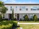 Modern townhome featuring a well-manicured lawn, symmetrical landscaping, and a contemporary facade at 10108 Sunnifa Aly, Orlando, FL 32832