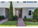 Modern townhome entrance featuring stone accents, contemporary door, and manicured landscaping at 10108 Sunnifa Aly, Orlando, FL 32832