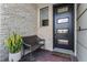Charming front porch featuring stone accents, a black modern door, and a welcome mat at 10108 Sunnifa Aly, Orlando, FL 32832