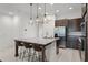 Modern kitchen island with a granite countertop, bar stools, and pendant lighting at 10108 Sunnifa Aly, Orlando, FL 32832
