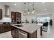 Open-concept kitchen with a large island and stylish pendant lighting, flowing into the living area at 10108 Sunnifa Aly, Orlando, FL 32832